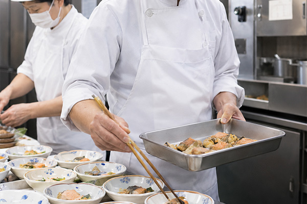 厨房で盛り付けを行うスタッフのイメージ